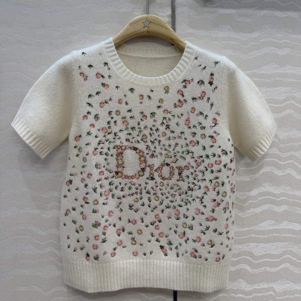 Close-up of multicolor daisy embroidery on white Dior cashmere sweater