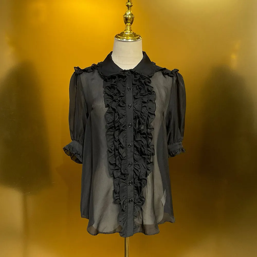 Close-up of D&G signature logo buttons on black chiffon shirt