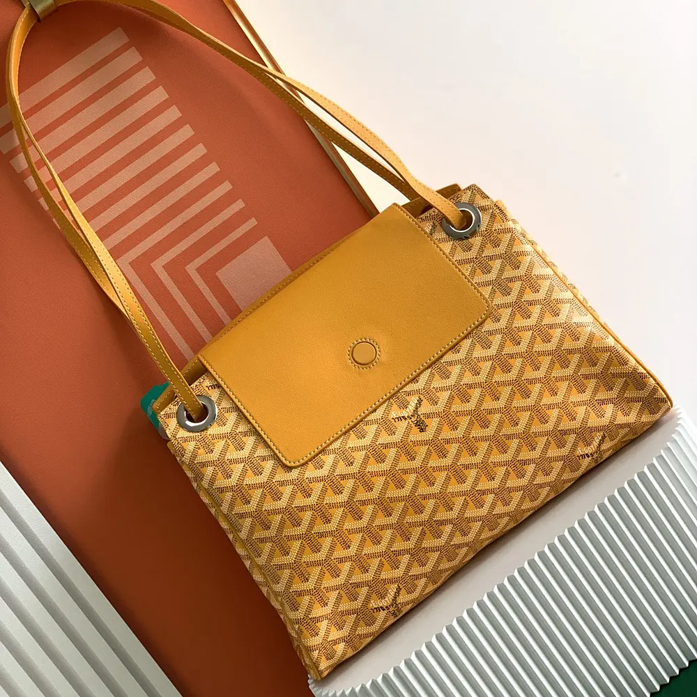 Close-up detail of yellow leather trim and brass hardware on Goyard Rouette Souple Bag