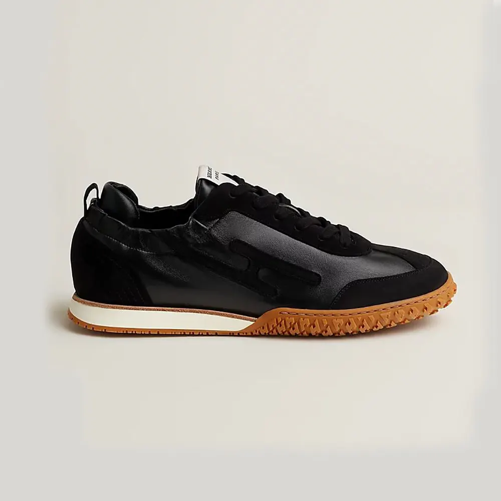 Side view of Hermes Unisex Jet Sneaker in black technical canvas suede