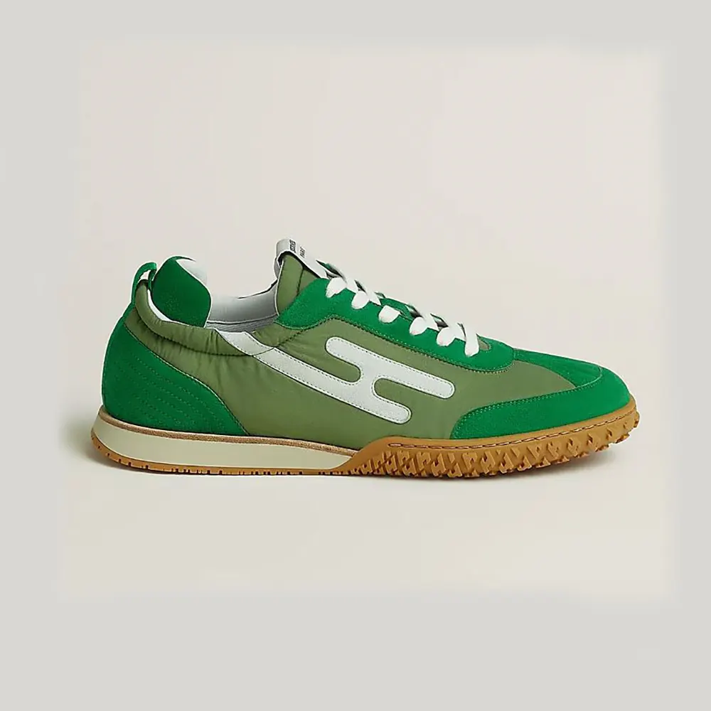 Side angle of Hermes Unisex Jet Sneaker in green technical canvas and suede