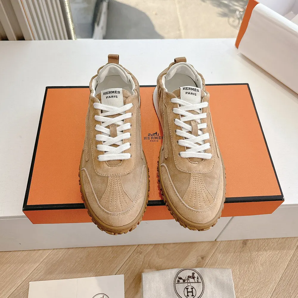 Close-up of Hermes embossed heel tab on Jet Sneaker in natural tone