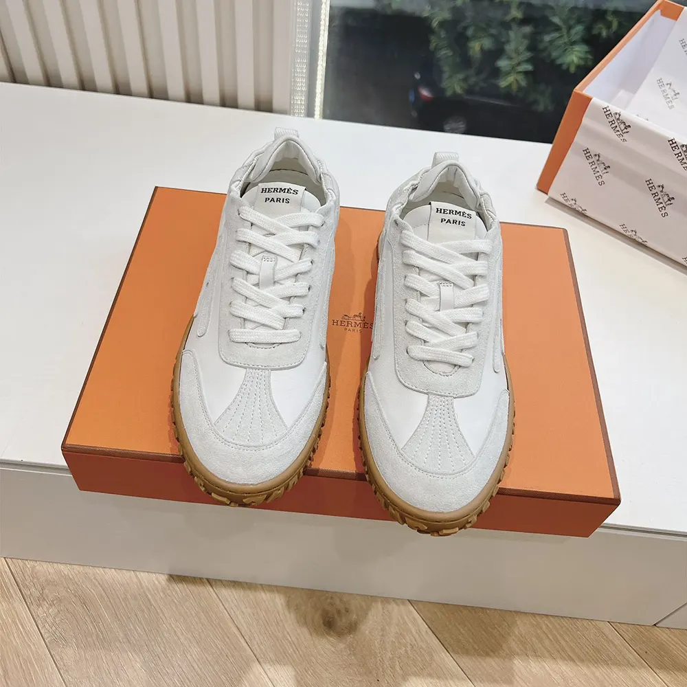 Close-up of Hermes logo embossed hardware on white Jet Sneaker