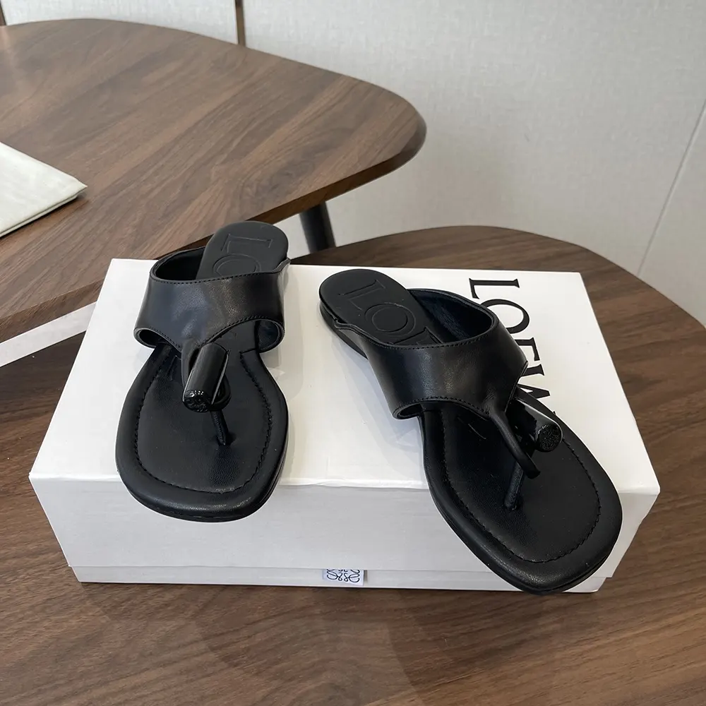 Top view showing glossy black leather and flat silhouette Loewe sandal