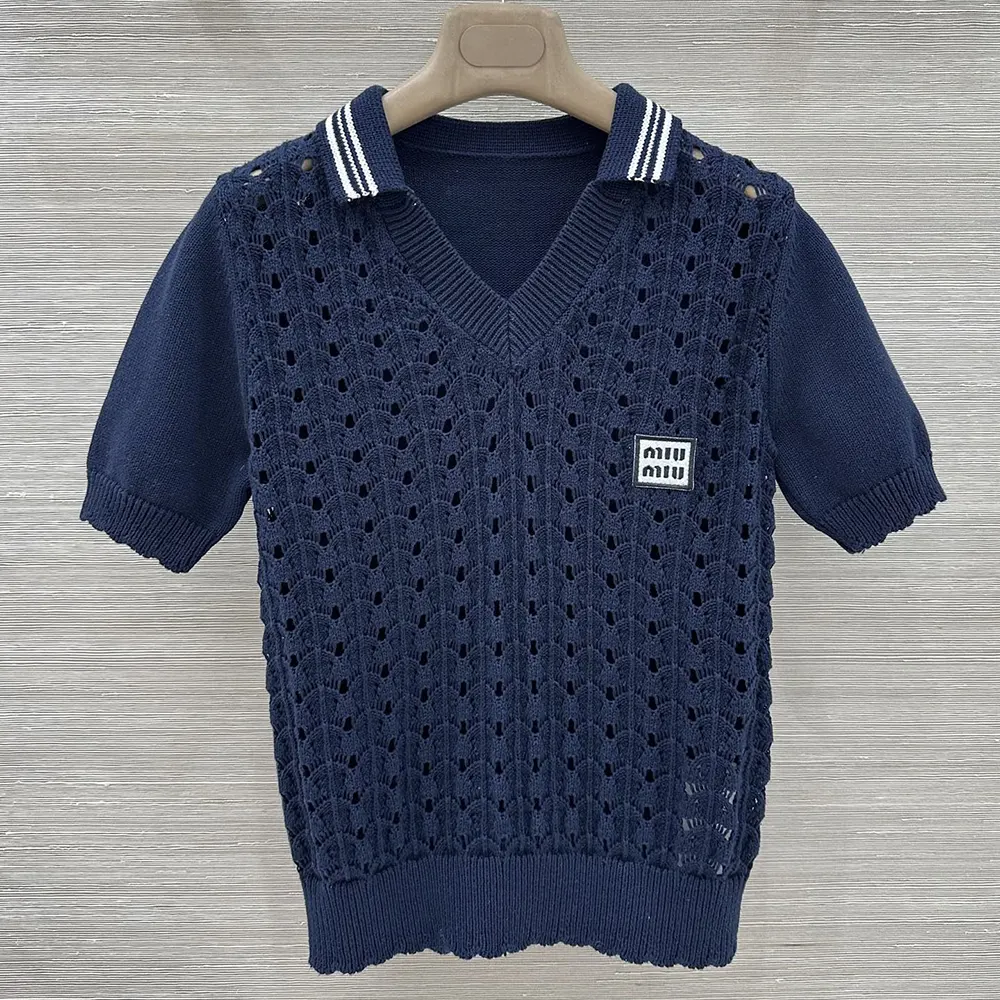 Close-up detail of embroidered Miu Miu logo on navy polo shirt
