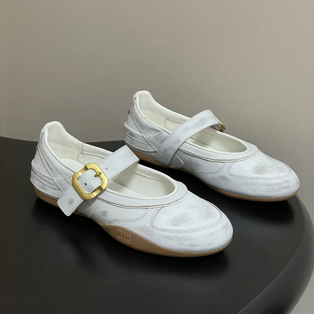 Close-up of silver buckle strap detail on white Miu Miu ballerinas