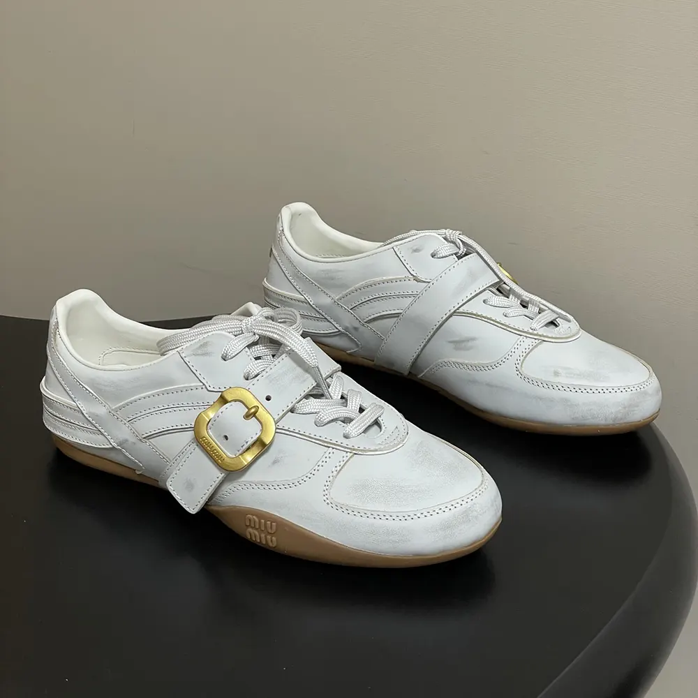 Close-up on the silver buckle strap detail of Miu Miu Women Gymnasium Sneakers