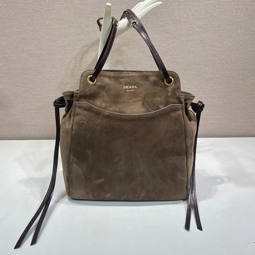 Close-up of gold-tone hardware on Prada Women Carry Medium Suede Tote Bag