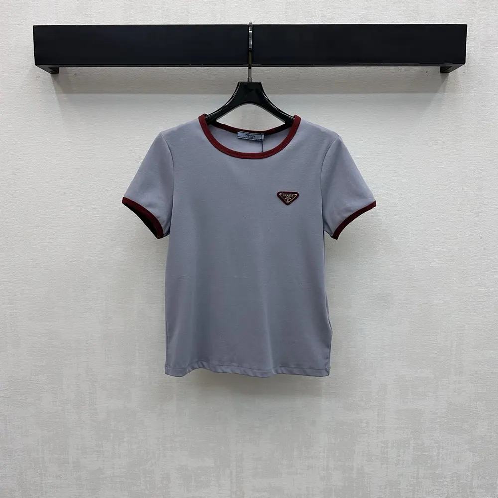 Close-up of light blue fabric and Prada logo detail on sleeve