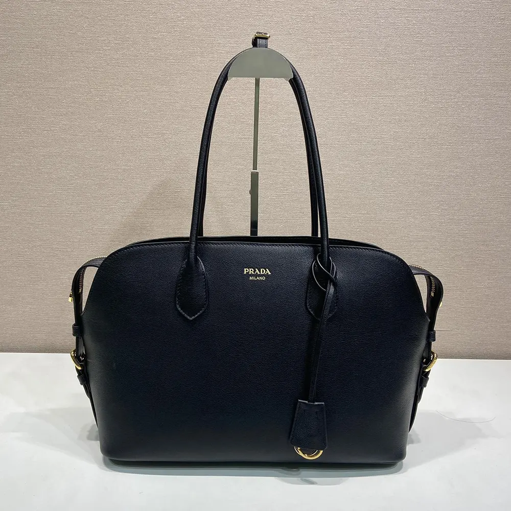 Close-up on silver-tone hardware and embossed Prada logo on tote bag