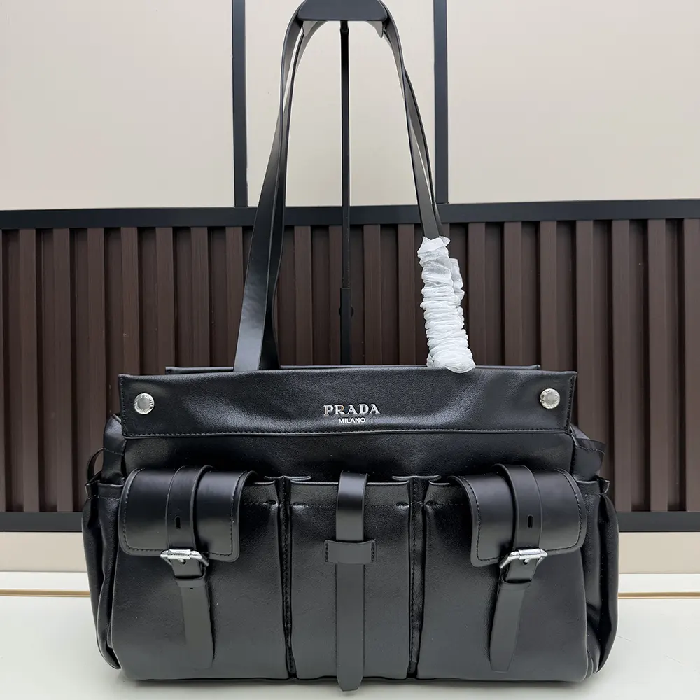 Close-up of silver Prada triangle detail on black leather tote