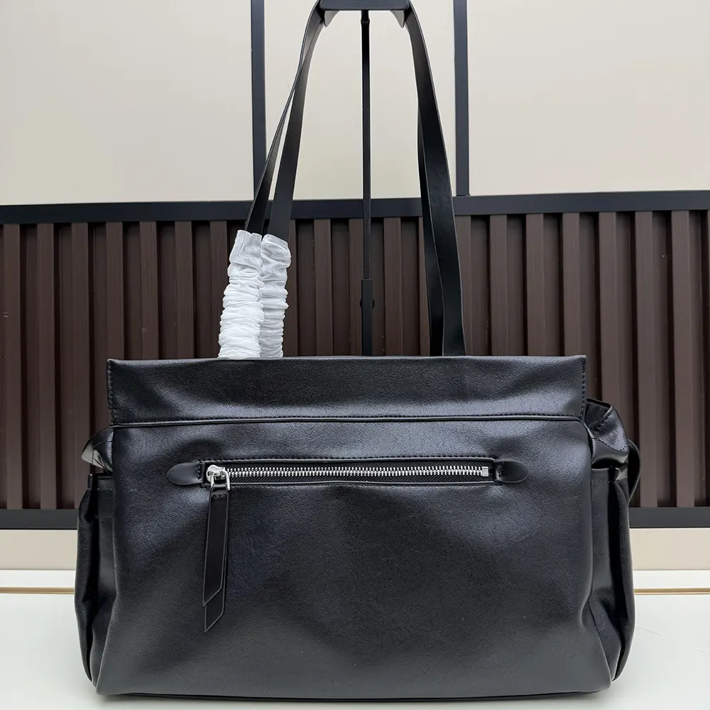 Side angle showing spacious interior and strap of Prada leather tote