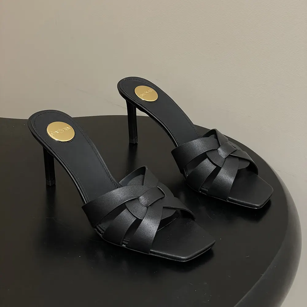 Close-up on gold YSL logo hardware on Tribute Mules black leather