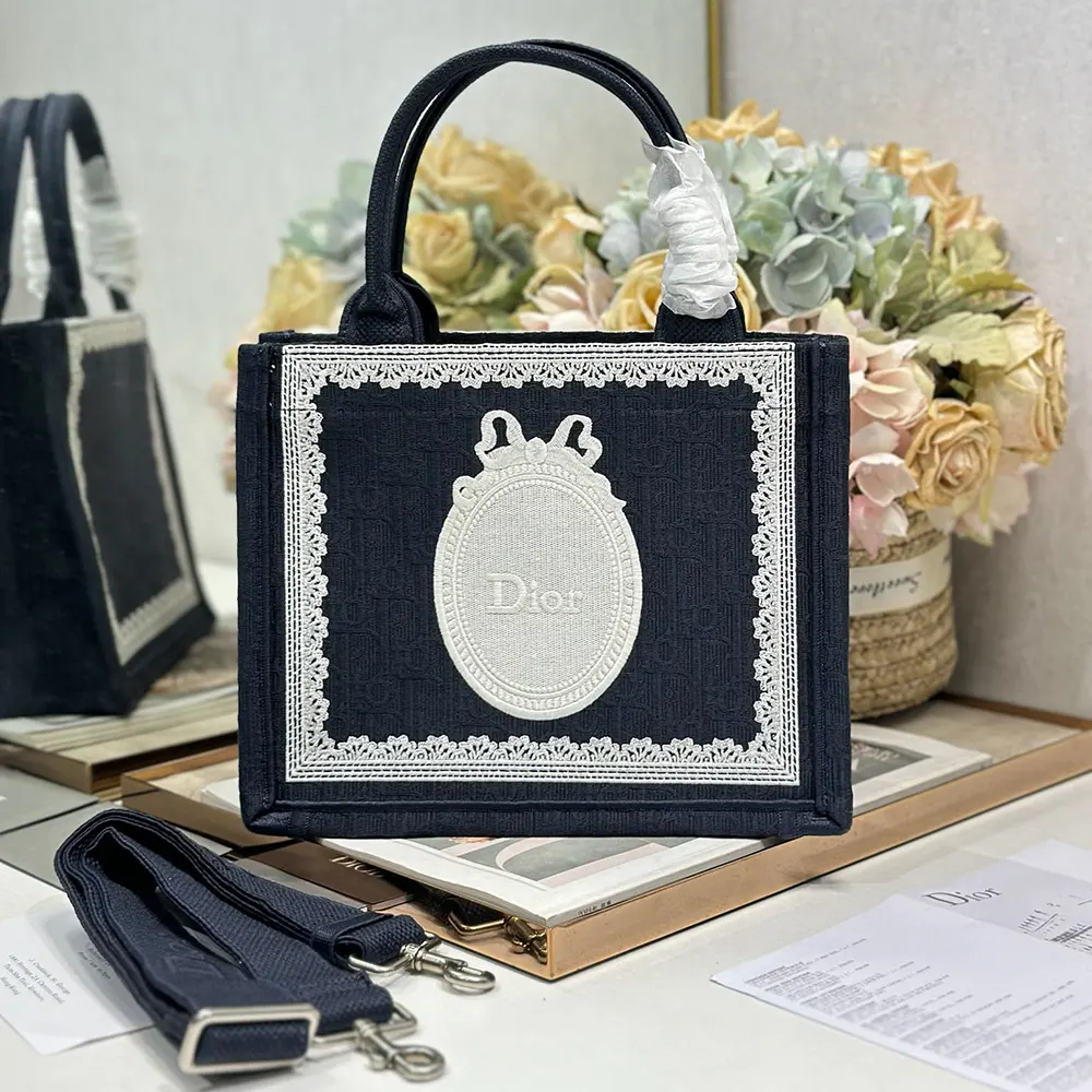 Close-up of white lace detail and Dior Médaillon on Small Dior Book Tote