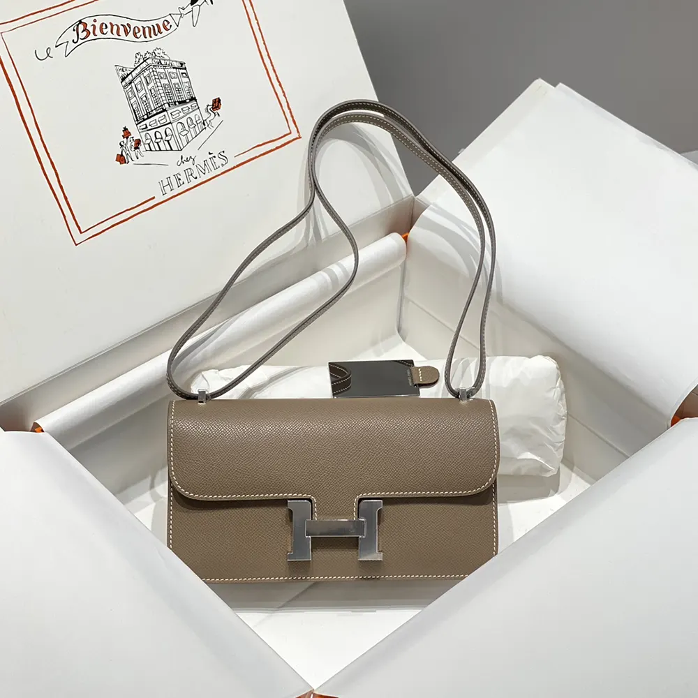 Side angle showing structured silhouette of Hermes Women Constance Elan Epsom Silver-Gray