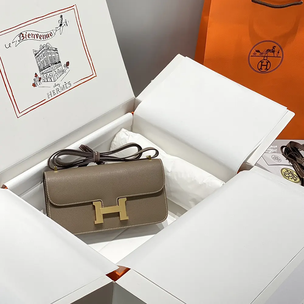 Side angle showing structured silhouette of Hermes Women Constance Elan Epsom Gold-Gray