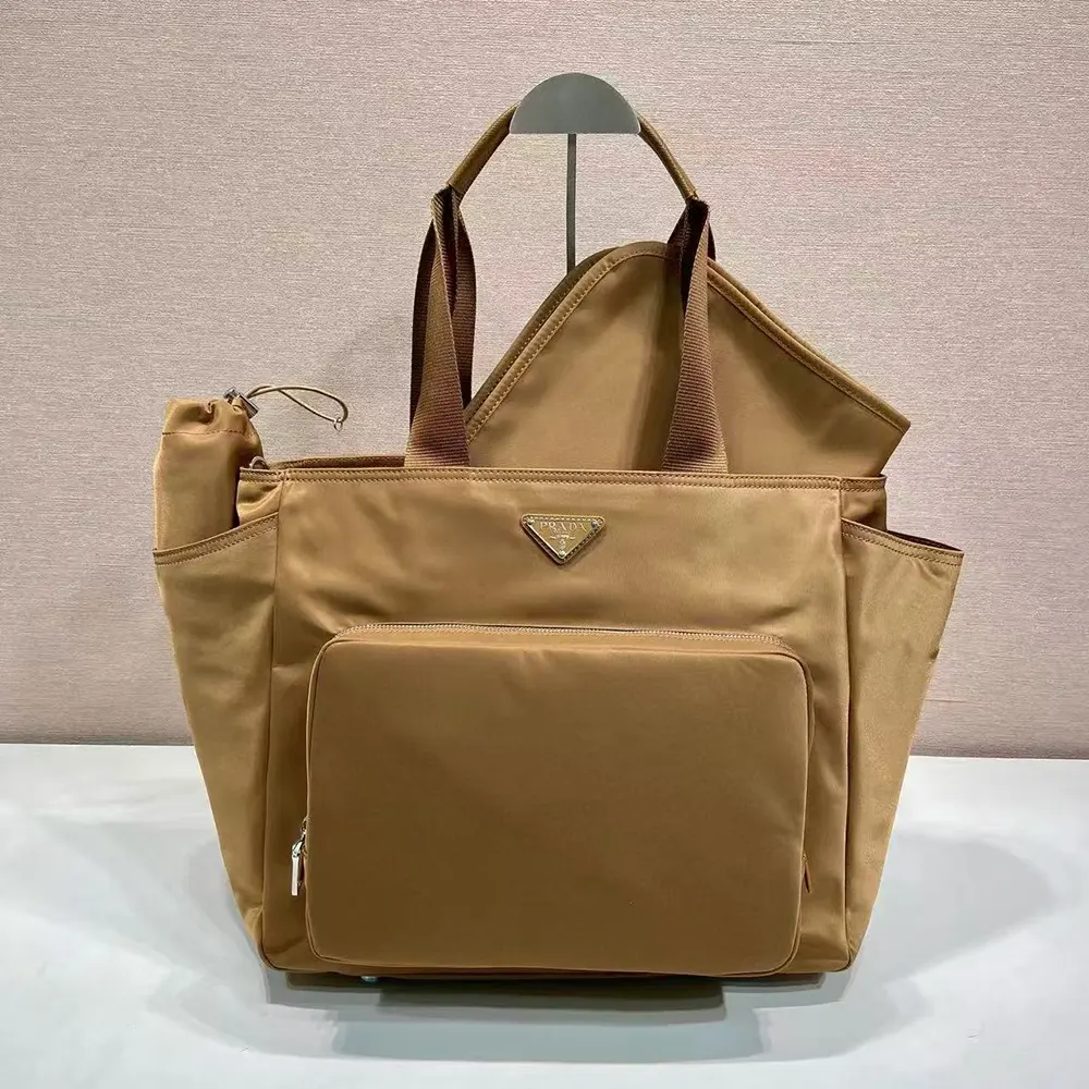 Close-up of triangular silver logo on Prada Re-Nylon Baby Bag in brown
