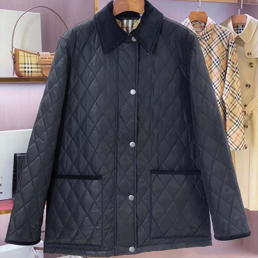 Close-up of Burberry logo hardware detail on black quilted nylon jacket
