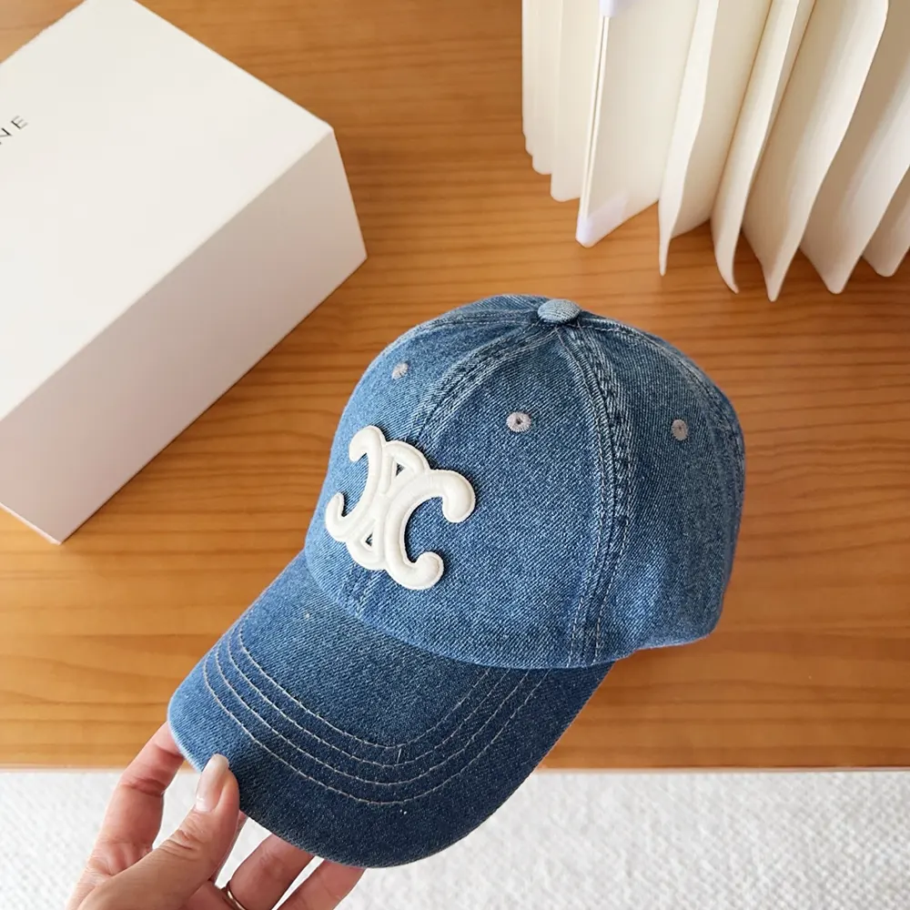 Close-up of gold Triomphe logo on denim cap front