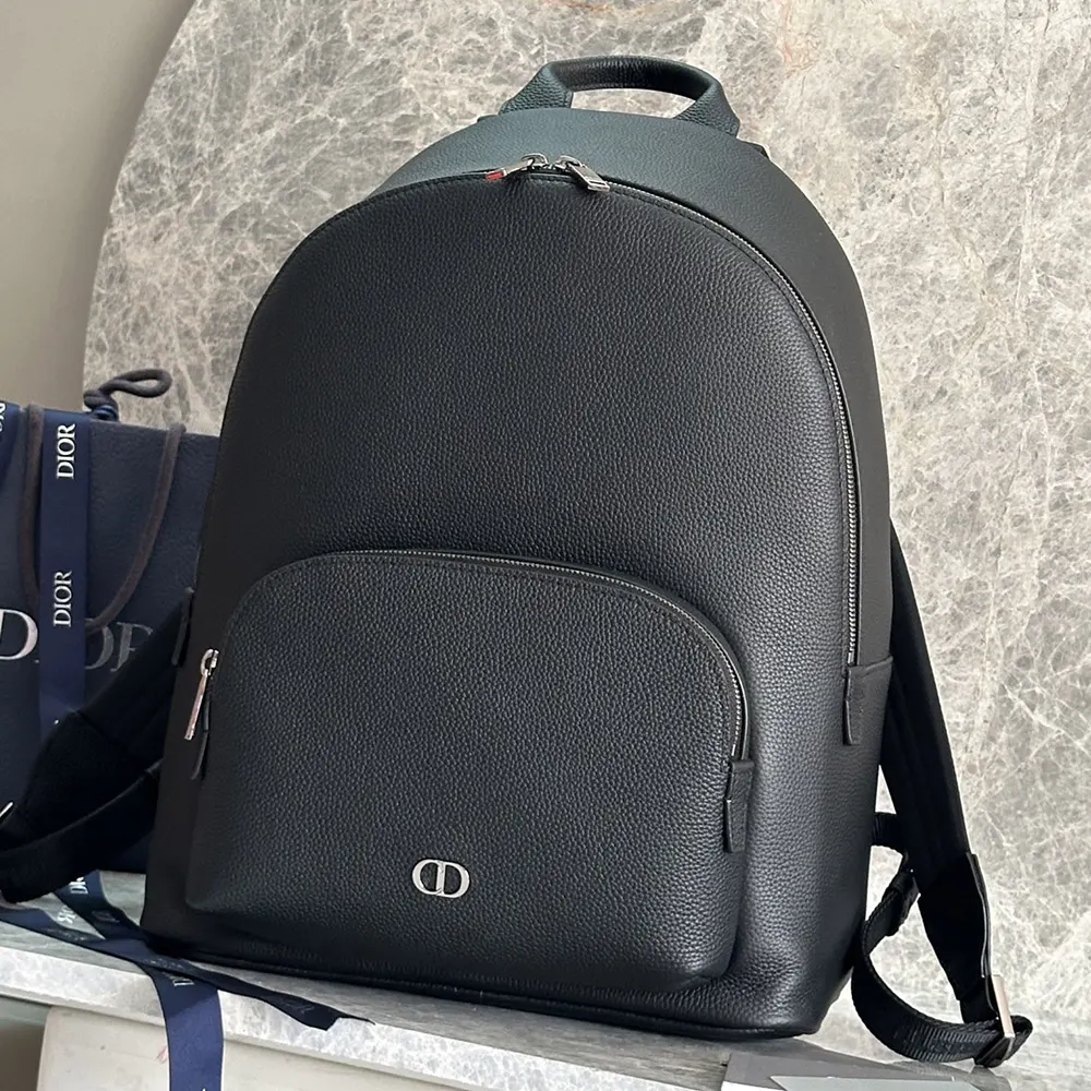 Close-up detail of silver-tone CD hardware on Dior Men CD Icon Backpack