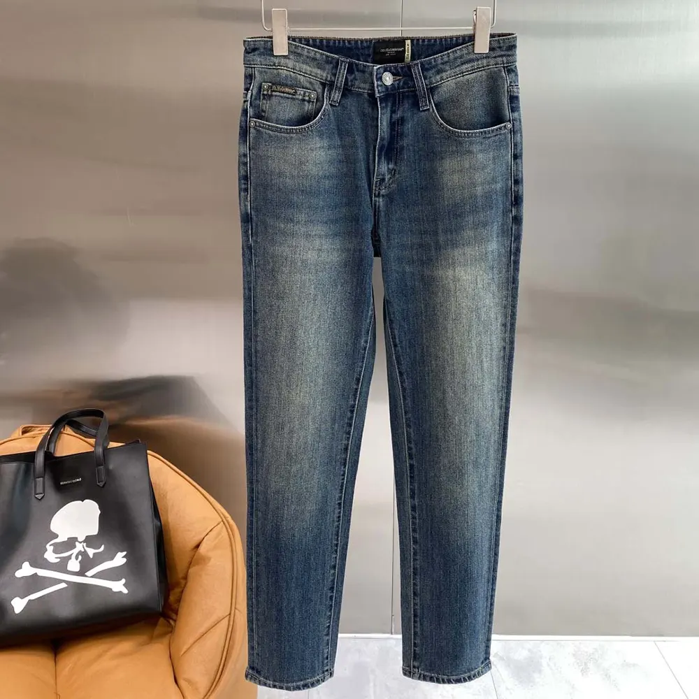 Close-up of branded metal buttons on Dolce Gabbana D&G Light Blue jeans