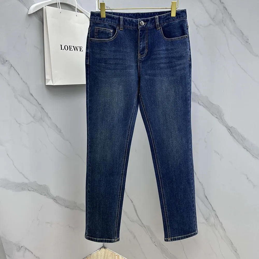 Close-up of blue cotton fabric and branded hardware on the jeans