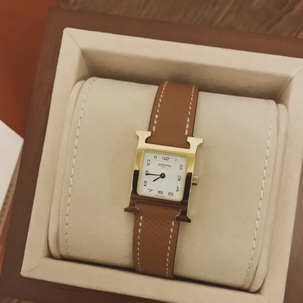 Side angle showing brown leather strap and polished stainless steel case