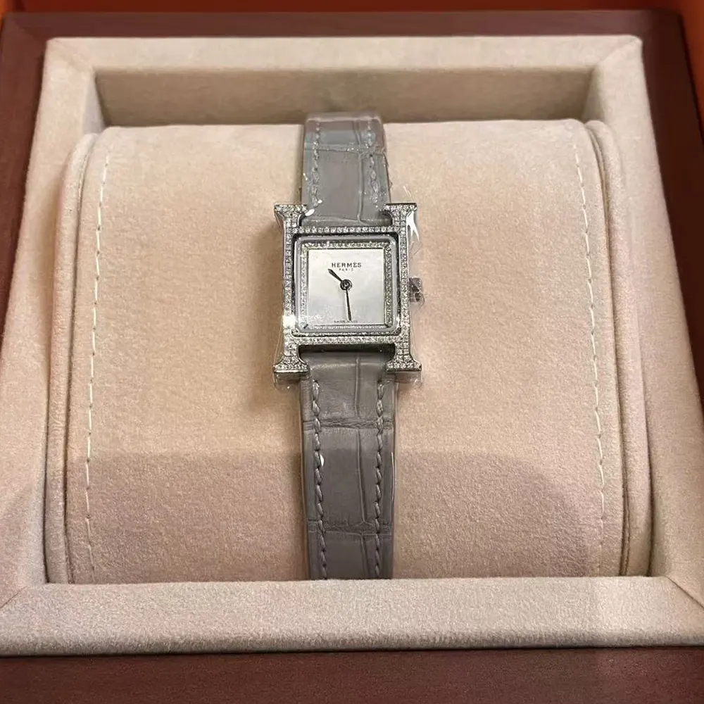 Close-up of Hermes signature H-shaped bezel on mini silver watch