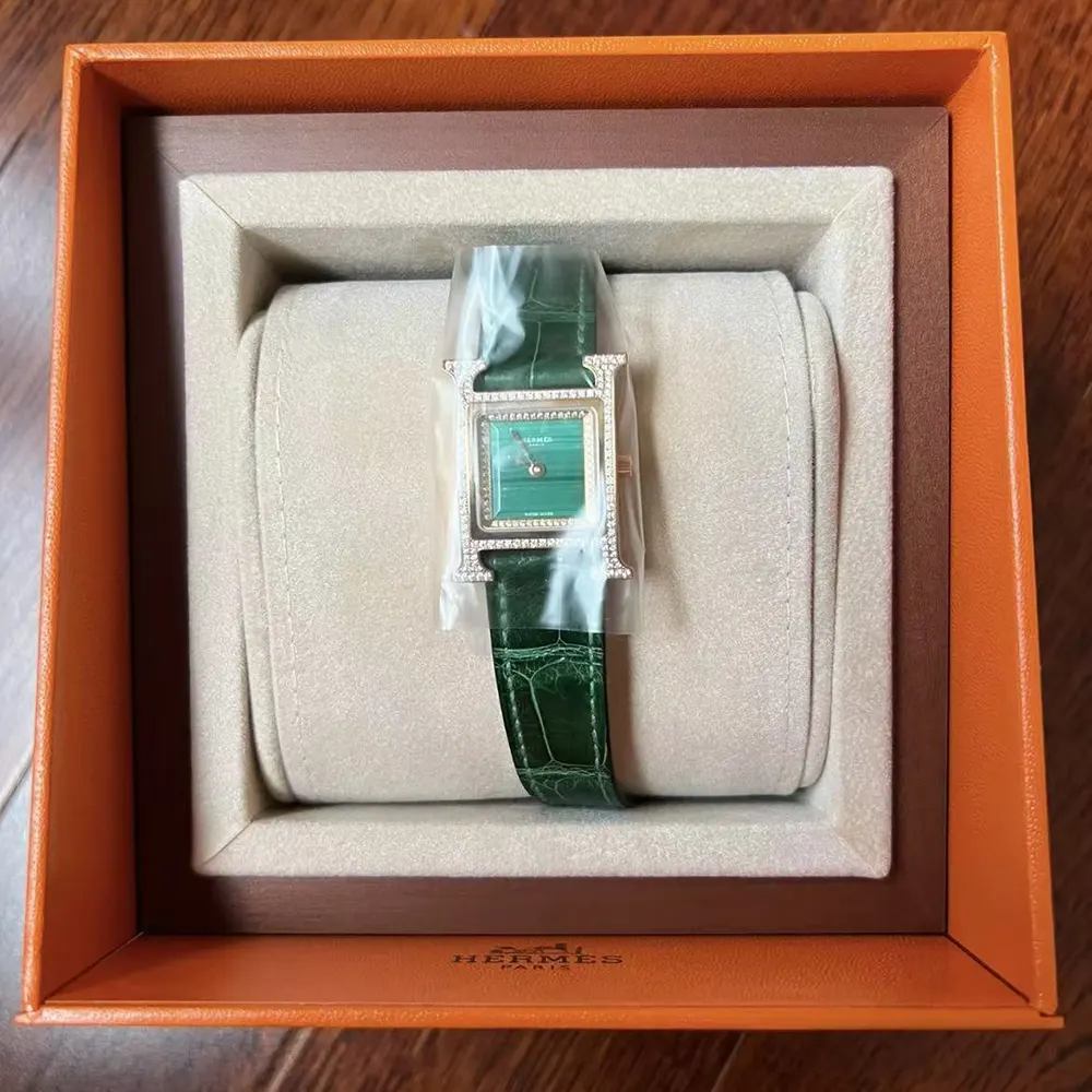 Close-up on Hermes Heure H watch green dial and stainless steel bezel