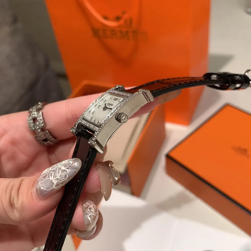 Side angle showing black leather strap and buckle of Hermes Women Heure H Watch