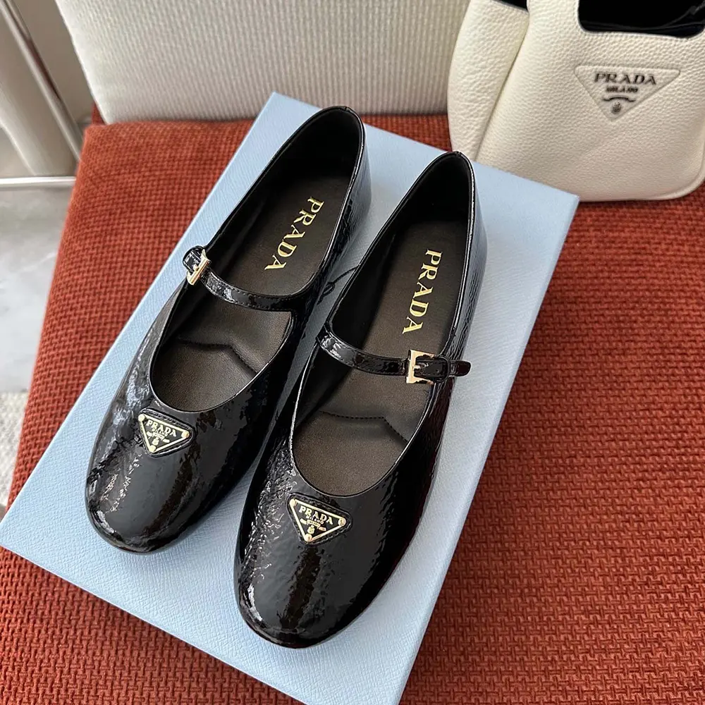 Close-up of glossy patent leather and Prada logo detail on ballerinas