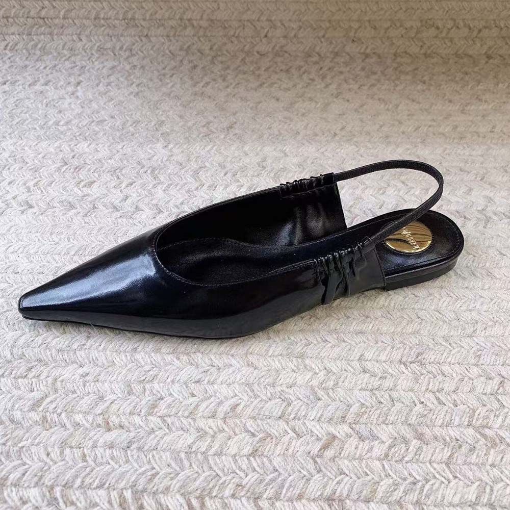 Close-up of gold YSL hardware detail on black Anne Marie slingback flats