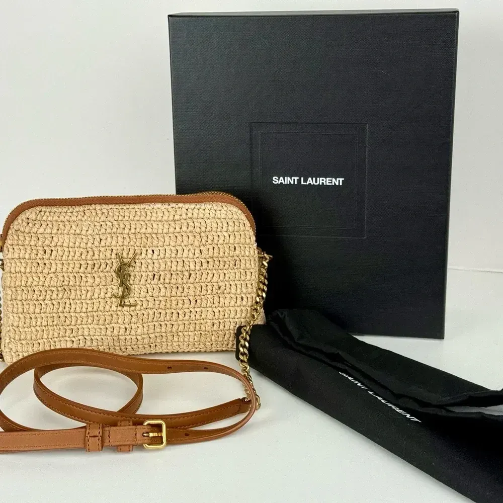 Close-up of gold YSL hardware on zipped pouch with raffia and leather