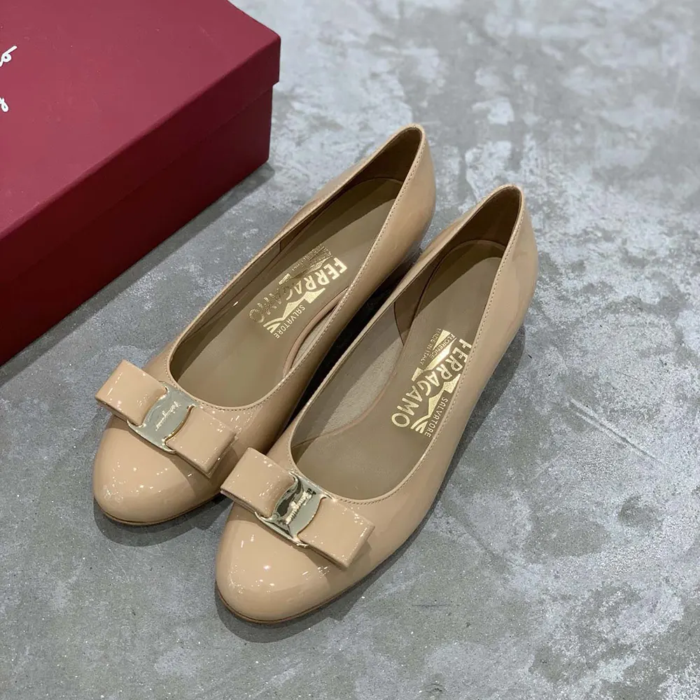 Close-up of the sandy leather and signature grosgrain bow on pump