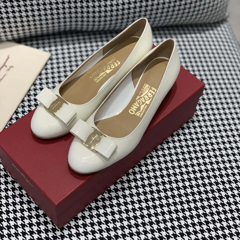 Close-up of white leather and gold-tone logo on Salvatore Ferragamo pump