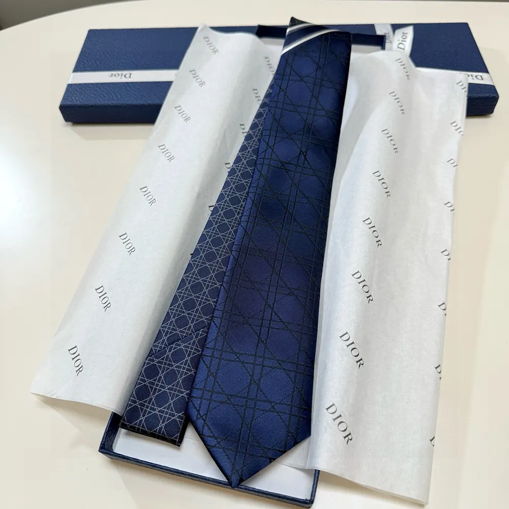 Styled shot of Dior Men Striped Cannage Tie with navy suit jacket