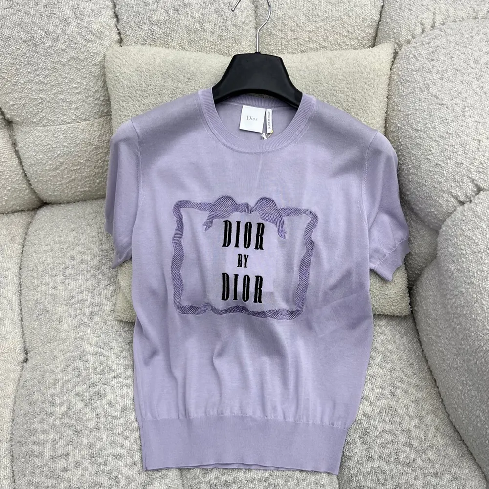 Close-up of embossed Dior trim on purple silk knit sweater