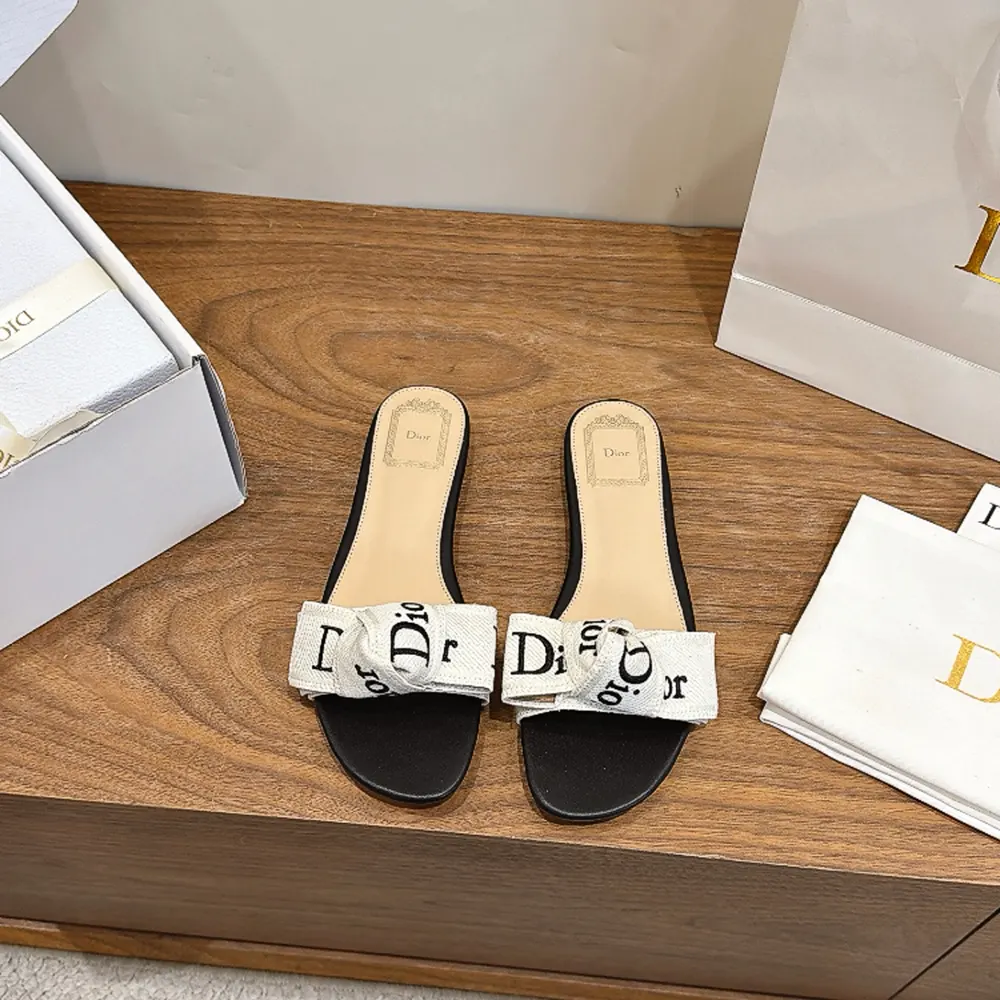 Close-up on black embroidered J’Adior detail on Dior slide sandal