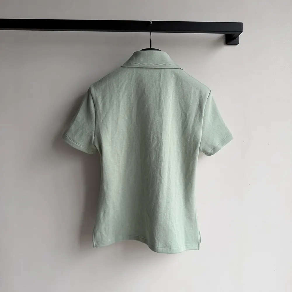 Side angle showing tailored fit of Dior Women Médaillon Embroidered Polo Shirt