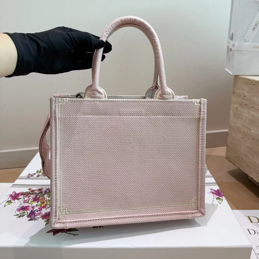 Side angle showing silver hardware and detachable strap on Dior medium tote