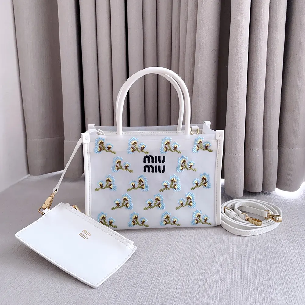 Close-up of embroidered mesh and gold hardware on Miu Miu handbag