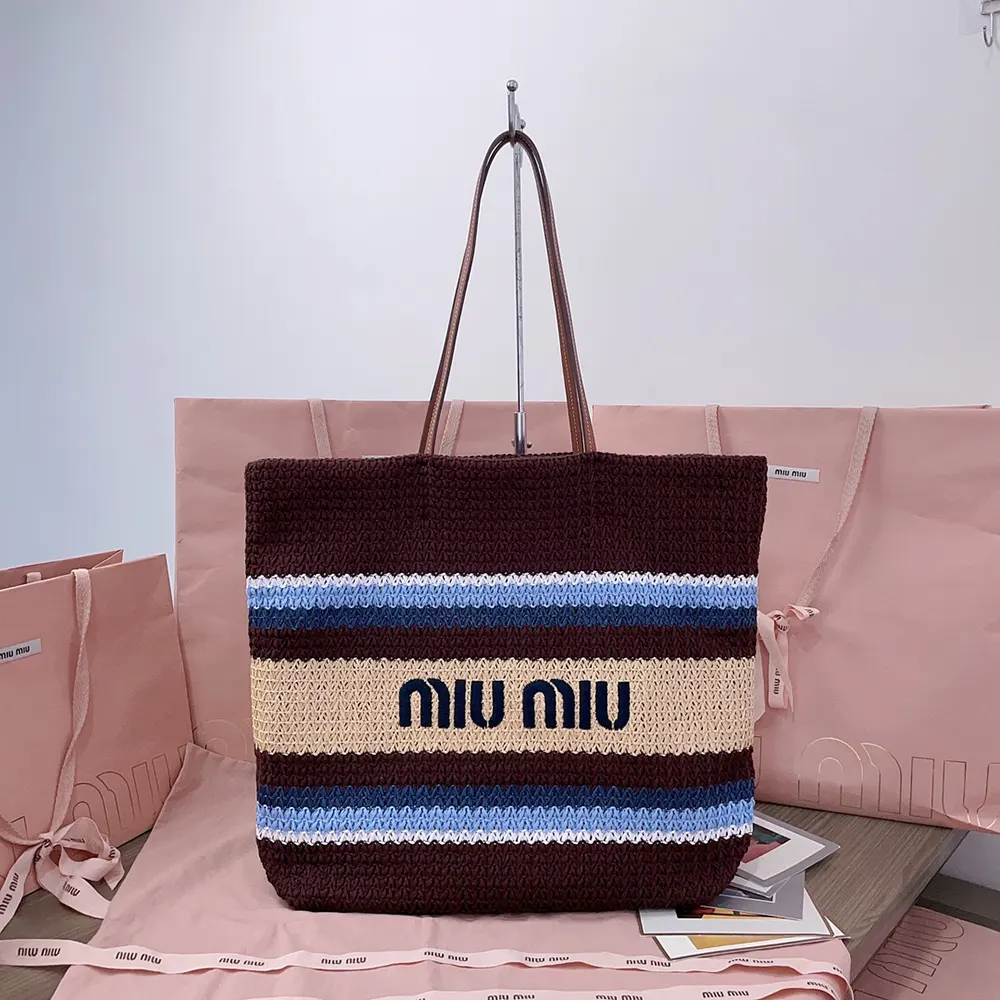 Close-up detail showing woven raffia texture and gold hardware on tote bag