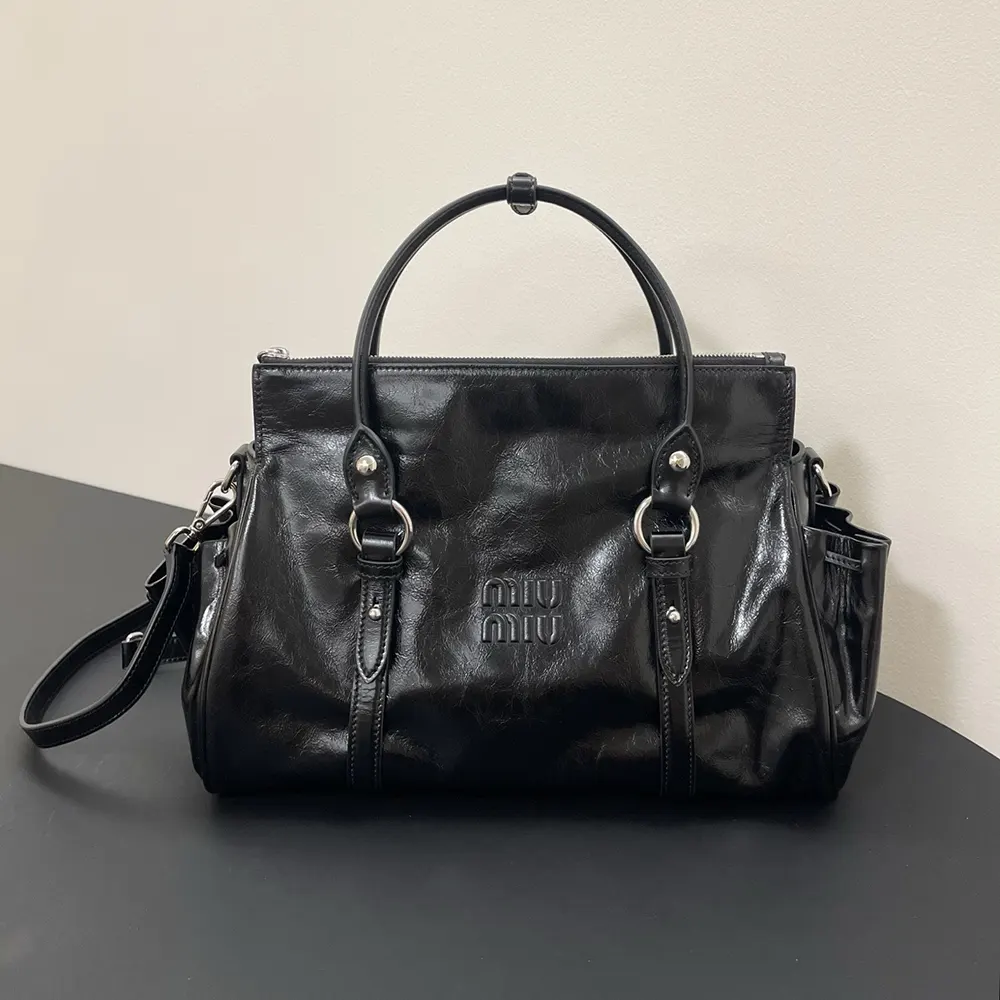 Close-up of shiny leather texture and silver hardware on Miu Miu handbag