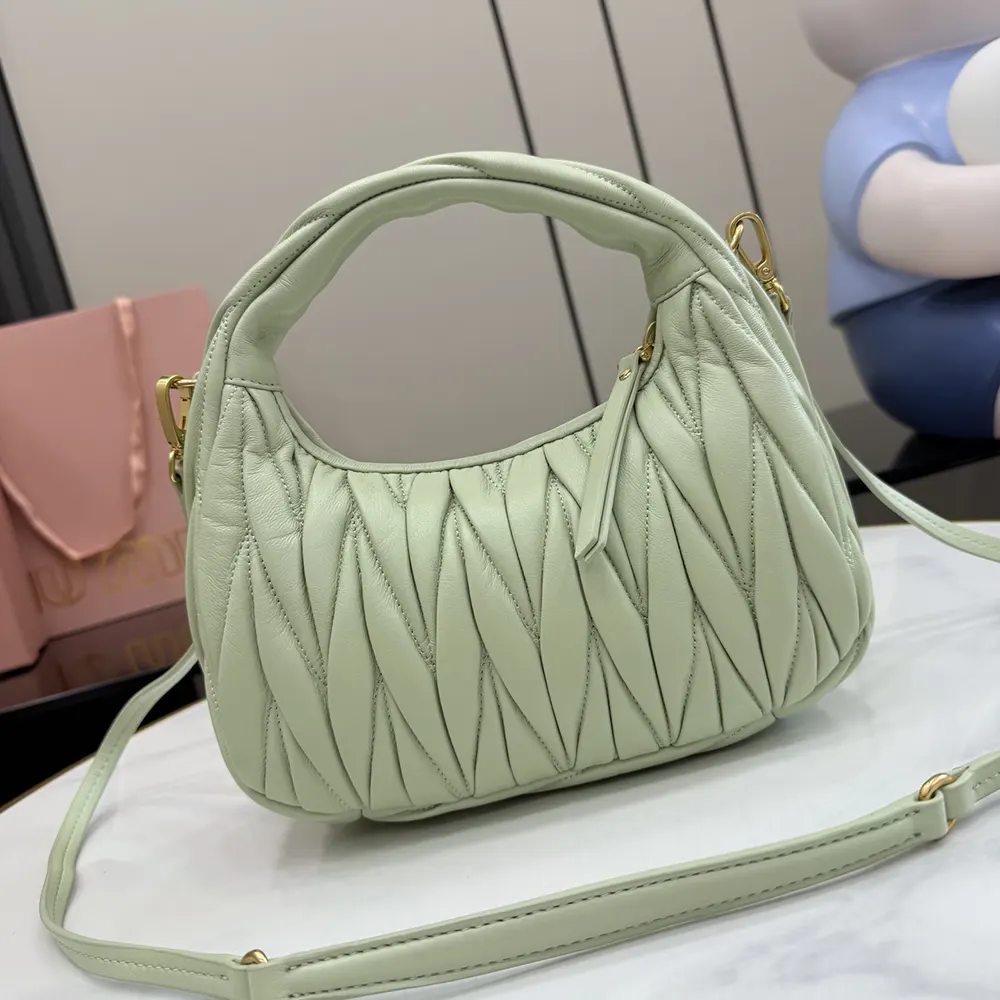 Side profile showing silver hardware on Miu Miu Women Wander Aqua leather bag