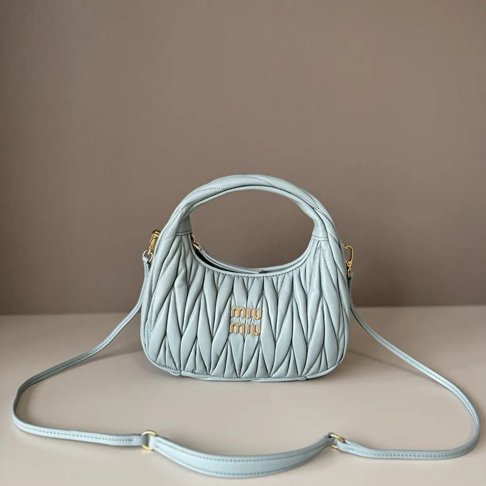 Close-up detail of powder blue matelassé texture and silver hardware on Miu Miu hobo