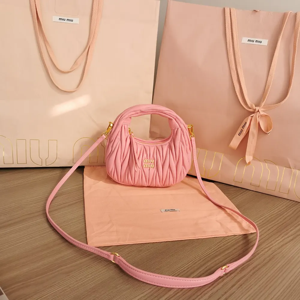 Side profile showing gold-tone closure on Miu Miu pink leather bag