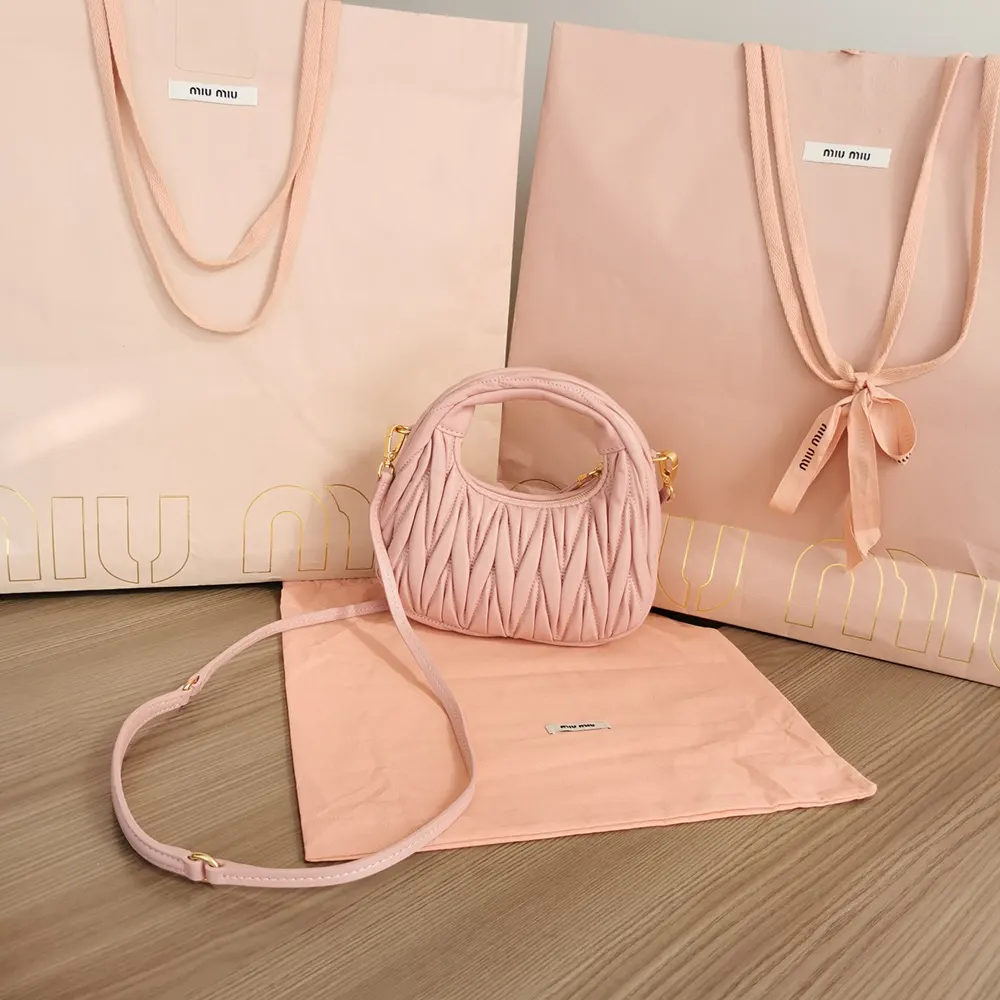 Side angle showing gold-tone hardware on Miu Miu powder pink leather bag