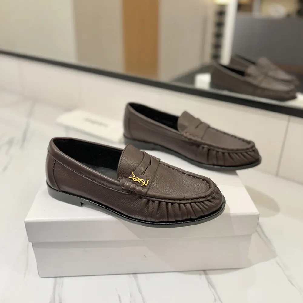 Close-up of signature YSL metal hardware on matte leather loafer