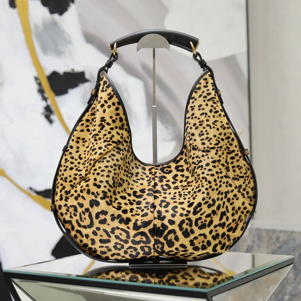 Close-up of gold YSL logo clasp on Mombasa Medium pony hair leather bag