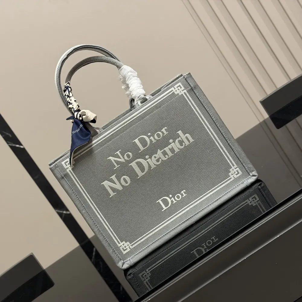 Close-up of signature No Dior No Dietrich embroidery on blue-greige canvas tote